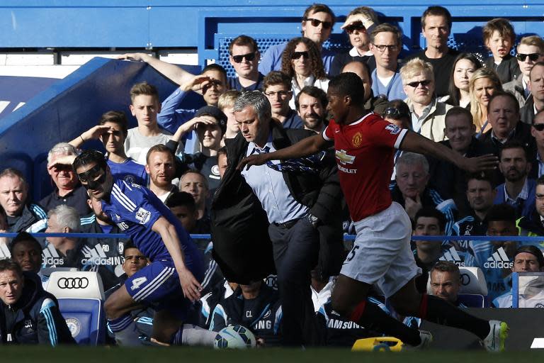 Manchester United's Antonio Valencia (R) and Chelsea's Cesc Fabregas (L) battle for the ball in front of Chelsea manager Jose Mourinho (C) during their English Premier League match at Stamford Bridge on April 18, 2015