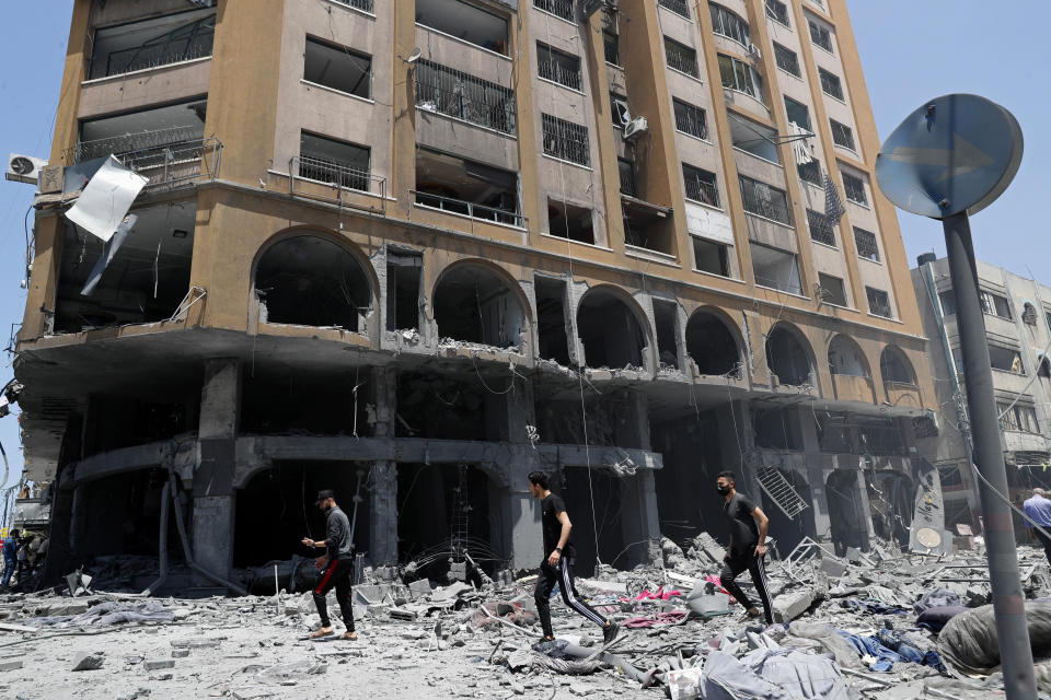 People inspect the rubble of a damaged building which was hit by an Israeli airstrike, in Gaza City, Wednesday, May 12, 2021. (AP Photo/Adel Hana)