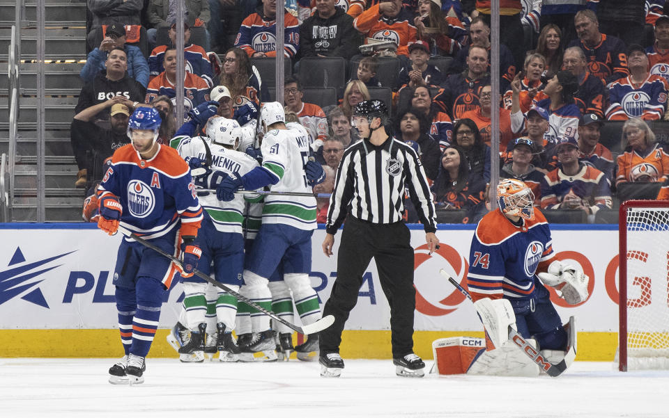 Vancouver Canucks players celebrate a goal against the Edmonton Oilers during the second period of an NHL hockey game in Edmonton, Alberta, Saturday, Oct. 14, 2023. (Jason Franson/The Canadian Press via AP)