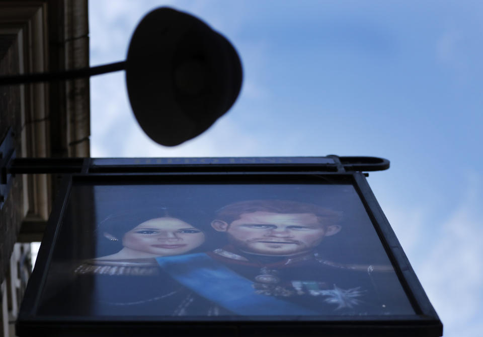 A sign depicting the image of Britain's Prince Harry and his wife Meghan, hangs outside the Duke of Sussex pub near Waterloo station, London, Tuesday March 9, 2021. Prince Harry and Meghan's explosive TV interview has divided people around the world, rocking an institution that is struggling to modernize with claims of racism and callousness toward a woman struggling with suicidal thoughts. (AP Photo/Frank Augstein)