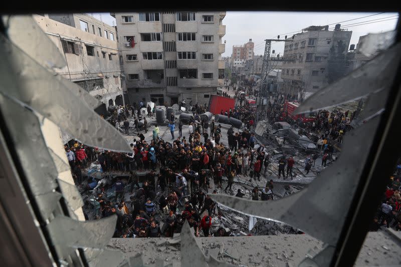 Palestinos reunidos en el lugar de un ataque israelí contra una casa, en medio del conflicto en curso entre Israel y el grupo islamista palestino Hamás, en Ráfah