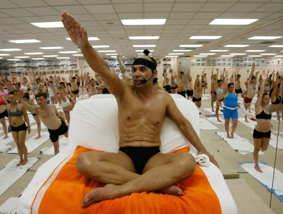 Bikram Choudhury (who goes by Bikram), seen here in 2006, has a chair at the front of his hot yoga class, which is filled with hundreds of students.