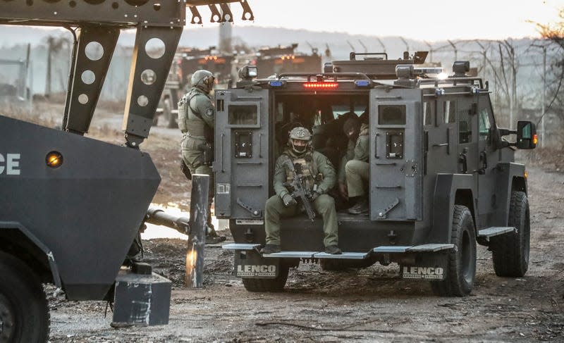 Law enforcement work at the site of a proposed public safety training center, clearing the woods in anticipation of construction on the controversial facility Monday, Feb. 6, 2023, in Atlanta.