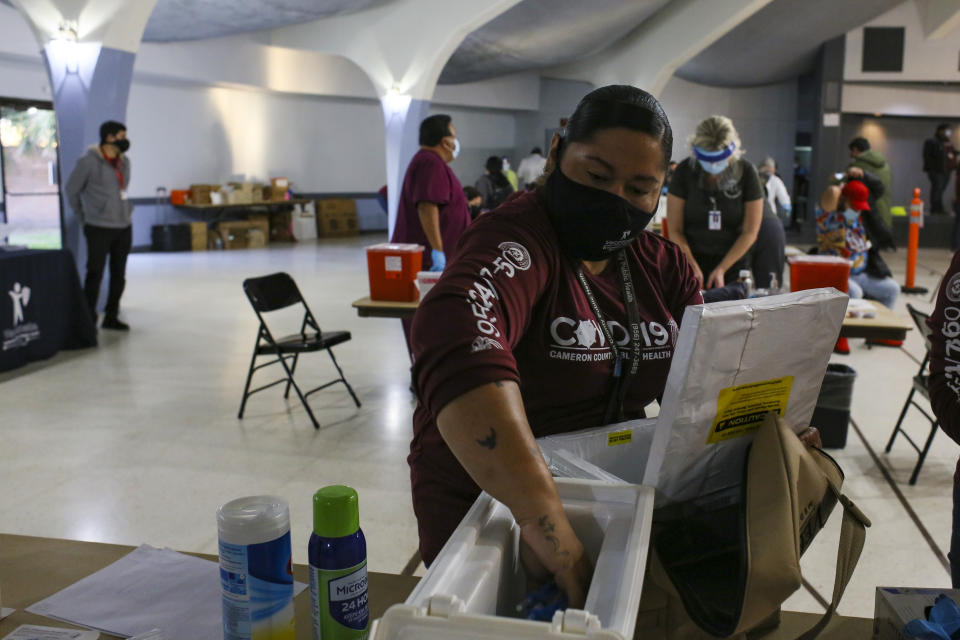 Cameron County Health Department Immunizations Specialist Esperanza Quintana refills each station's supply of pre-measured syringes of the Moderna COVID-19 vaccine, Friday, Jan. 8, 2021, at the COVID-19 vaccine clinic inside Casa Del Sol in Harlingen, Texas. (Denise Cathey/The Brownsville Herald via AP)