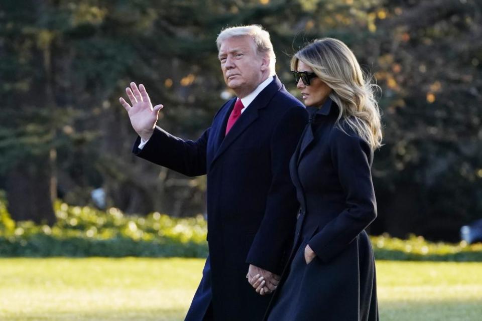 Donald and Melania Trump walk at the White House in December.