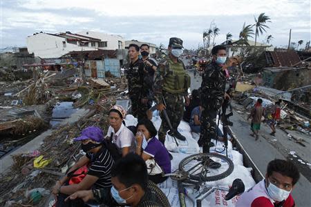 Soldiers and residents look at the devastation of the town from a military aid supplies distribution truck after the Super typhoon Haiyan battered Tacloban city