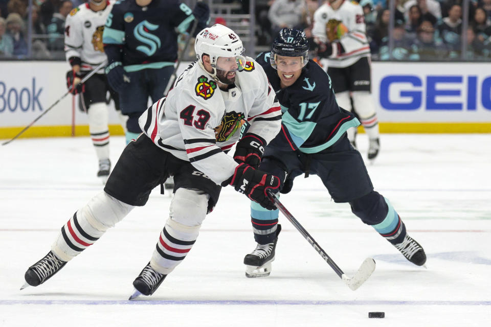 Chicago Blackhawks center Colin Blackwell (43) and Seattle Kraken center Jaden Schwartz (17) compete for the puck during the first period of an NHL hockey game Wednesday, Jan. 24, 2024, in Seattle. (AP Photo/Jason Redmond)