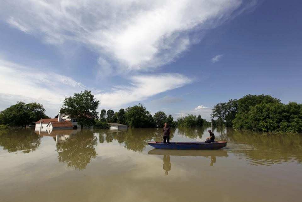 Villagers paddle during heavy floods in the village of Prud