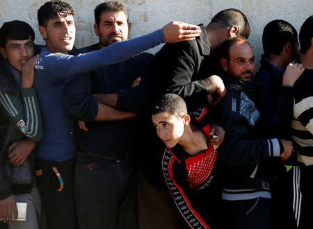 Men wait for food to be distributed by an Iraqi government organisation in Mosul, Iraq November 24, 2016. REUTERS/Goran Tomasevic