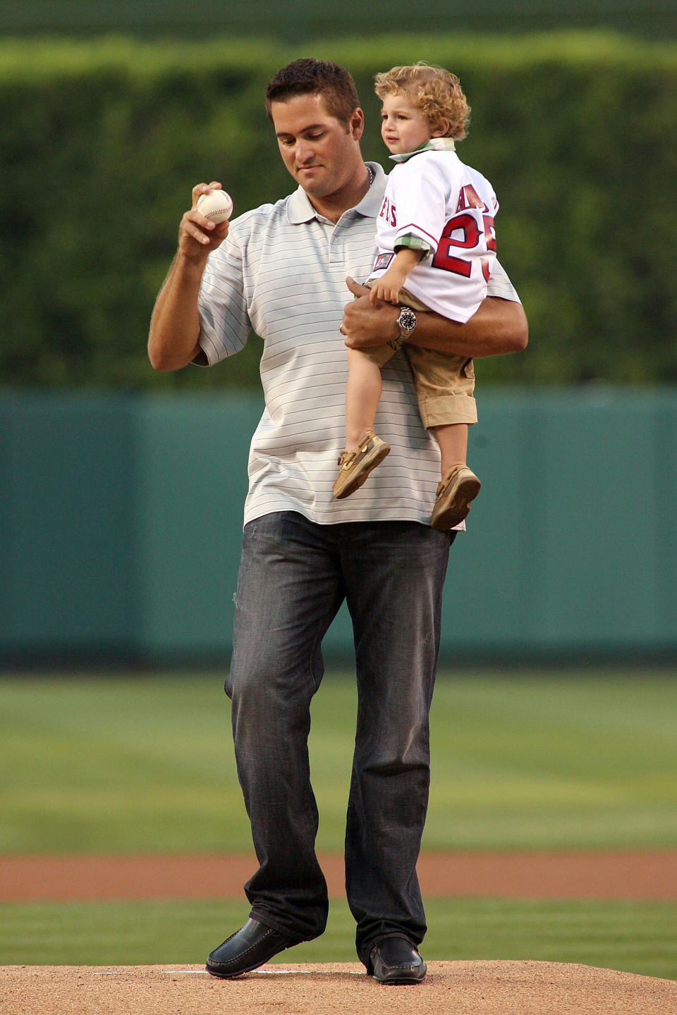 ANAHEIM, CA - AUGUST 17:  Former Angel (1998- 2004) and 2002 World Series MVP Troy Glaus throws out the honorary first pitch while holding his son Ty Glaus before the game between the Tampa Bay Rays and the Los Angeles Angels of Anaheim at Angel Stadium of Anaheim on August 17, 2012 in Anaheim, California.  (Photo by Jeff Golden/Getty Images)