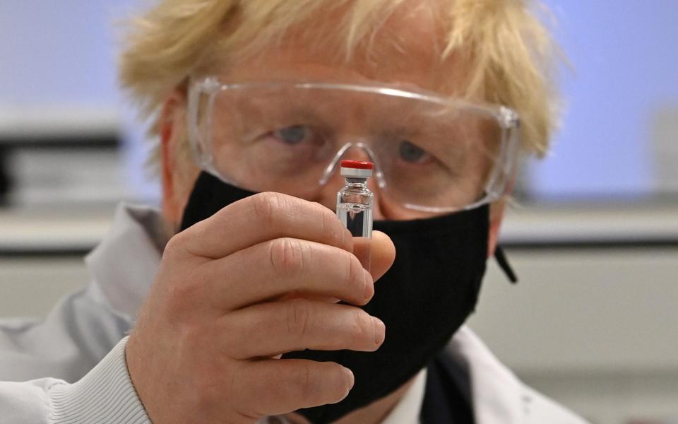 Boris Johnson holds a vial containing the covid vaccine