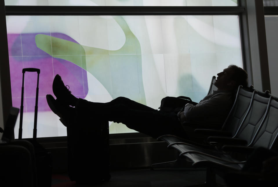 A traveler naps at he waits for his flight at Indianapolis International Airport in Indianapolis, Wednesday, Nov. 21, 2018. The airline industry trade group Airlines for America expects that Wednesday will be the second busiest day of the holiday period behind only Sunday, when many travelers will be returning home after Thanksgiving. (AP Photo/Michael Conroy)