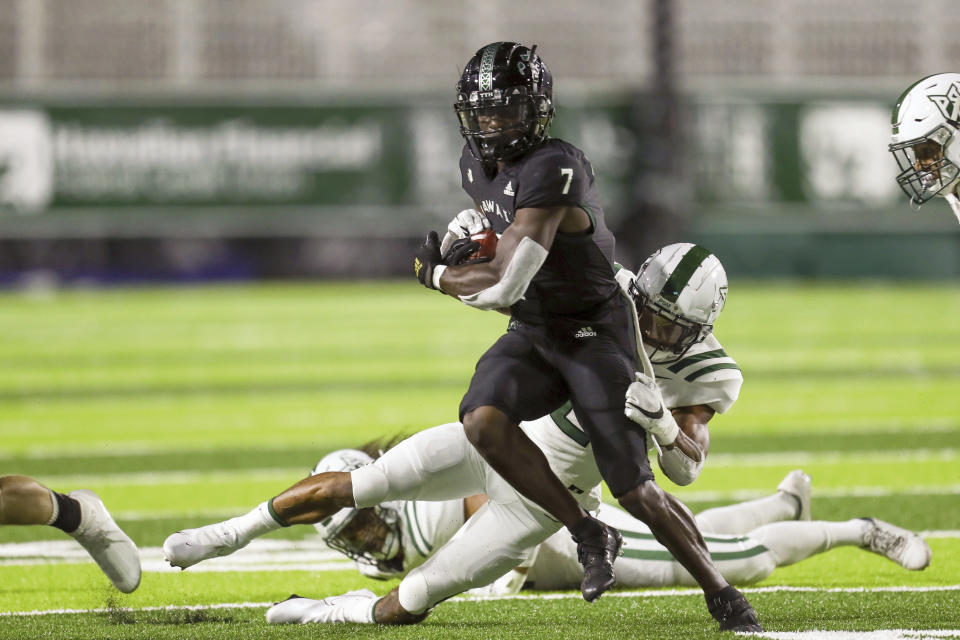 Hawaii running back Calvin Turner Jr. (7) is tackled by Portland State safety Xavier Bell (2) during the first half of an NCAA college football game, Saturday, Sept. 4, 2021, in Honolulu. (AP Photo/Darryl Oumi)