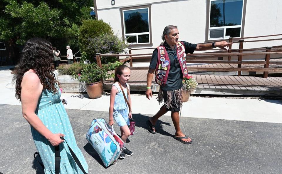 Cardiologist Dr. Kavin Desai directs Emily Urias Ponce, 9, to her cabin at Camp Taylor in Grayson, Calif., Thursday, June 11, 2024. Dr. Desai has been Camp Taylor’s medical director since it’s founding in 2002.