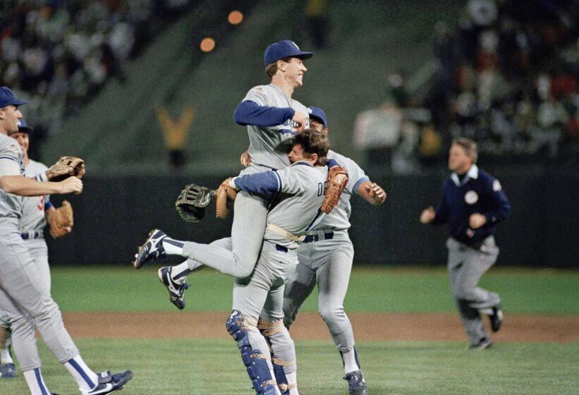 Orel Hershiser is lifted in the air by Rick Dempsey after the Dodgers' 5-2 win over the Oakland Athletics on Oct. 21, 1988.