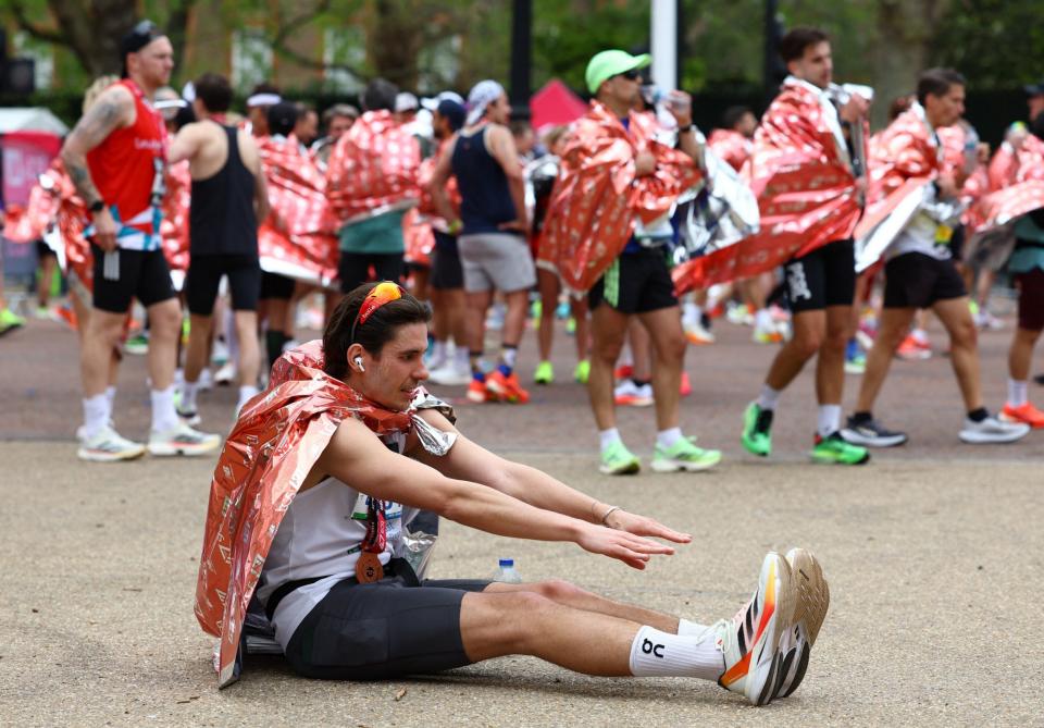 A finisher stretches having run the 26.2 miles