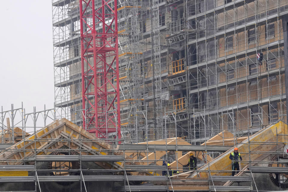 Workers building the Olympic Village at the Porta Romana former railway yard, in Milan, Italy, Tuesday, Feb. 6, 2024. The 2026 Milan-Cortina Olympics start exactly two years from Tuesday and it still seems like there are more questions than answers for a complicated games that will be staged across a large swath of northern Italy spread between five different venue clusters. (AP Photo/Antonio Calanni)