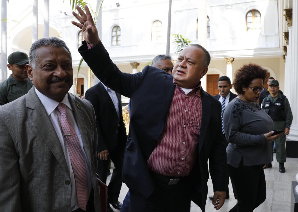 Diosdado Cabello, Venezuela's socialist party boss and president of the National Constituent Assembly, waves as he arrives to attend a session in Caracas, Venezuela, Tuesday, April 2, 2019. Lawmakers loyal to President Nicolas Maduro considered whether to strip National Assembly leader Juan Guaido of immunity on Tuesday in a move that would pave the way to prosecute and potentially arrest him for allegedly violating the constitution after declaring himself interim president. (AP Photo/Ariana Cubillos)