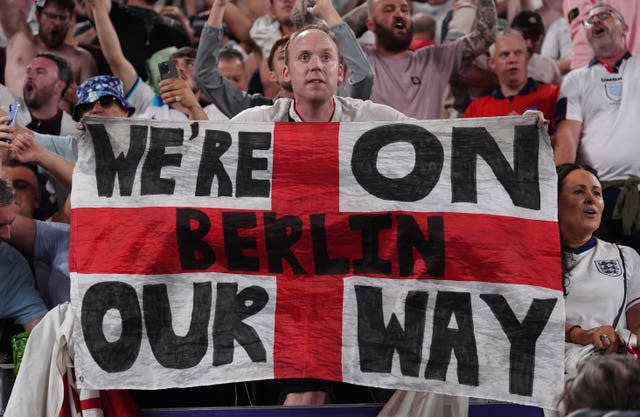 England fans with a flag banner at full time after the Euro 2024 semi-final match against the Netherlands