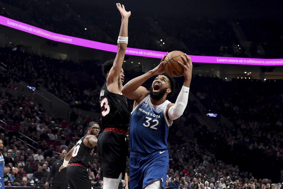 Minnesota Timberwolves center Karl-Anthony Towns, right, drives to the basket as Portland Trail Blazers forward Toumani Camara, left, defends during the first half of an NBA basketball game in Portland, Ore., Thursday Feb. 15, 2024. (AP Photo/Steve Dykes)