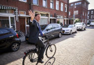 Netherlands Prime Minister Mark Rutte leaves on his bike after voting in the European elections in The Hague, Netherlands, Thursday, May 23, 2019. (AP Photo/Phil Nijhuis)