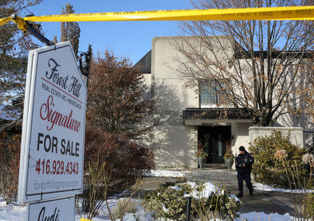 A police forensics photographer works outside the home of billionaire founder of Canadian pharmaceutical firm Apotex Inc., Barry Sherman and his wife Honey, who were found dead under circumstances that police described as "suspicious," in Toronto, Ontario, Canada December 16, 2017. REUTERS/Chris Helgren