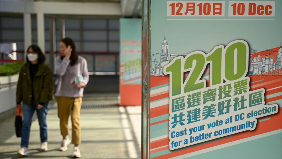Pedestrians walk past posters promoting the district council elections in Hong Kong. - Peter Parks/AFP/Getty Images