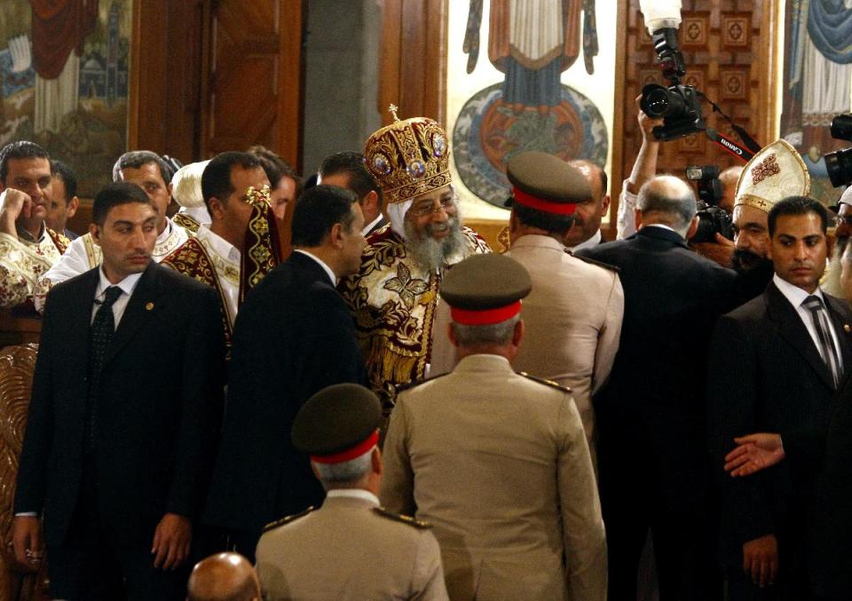 In this late Saturday, April 19, 2014 photo, Coptic Pope Tawadros II, center, greets a delegation from the Egyptian army at St. Mark's Cathedral during Easter Eve service, in Cairo, Egypt. Egypt's former military chief, retired Field Marshal Abdel-Fattah el-Sissi, and presumed presidential front-runner visited the Coptic pope earlier on Saturday ahead of Orthodox Easter, making his first public appearance since he formally made his bid for the presidency. (AP Photo/Ahmed Abdel Fattah, El Shorouk) EGYPT OUT