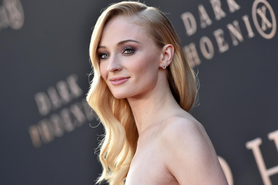 Sophie Turner in elegant attire smiling at a premiere