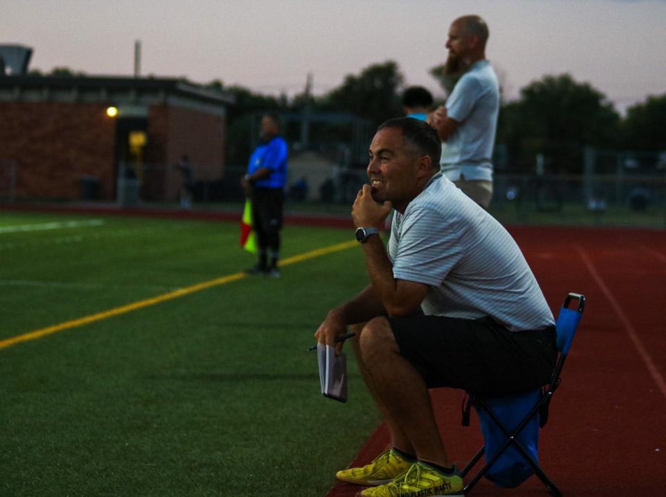 Salina South boys head soccer coach Trey Crow encourages his team on the sidelines during a game against Newton in September.