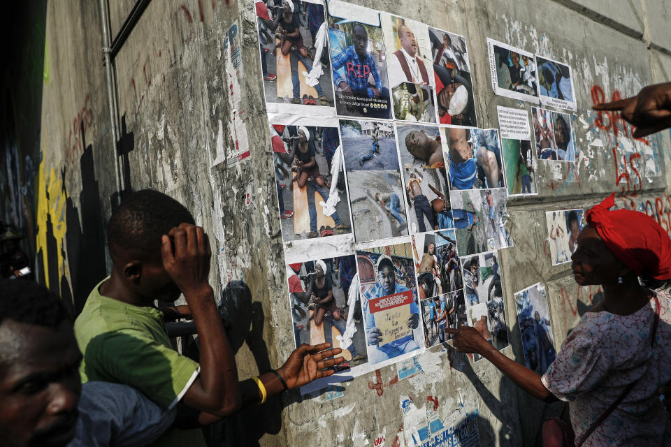 Protesters and passerby look at images on a wall of people said to have been injured or killed during the past month of protests calling for the resignation of President Jovenel Moise, in Port-au-Prince, Haiti, Oct. 15, 2019. The image was part of a series of photographs by Associated Press photographers which was named a finalist for the 2020 Pulitzer Prize for Breaking News Photography. (AP Photo/Rebecca Blackwell)