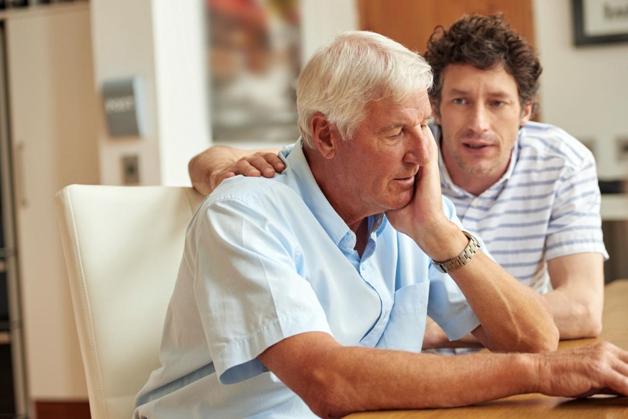 young man looking concerned talking to senior relative