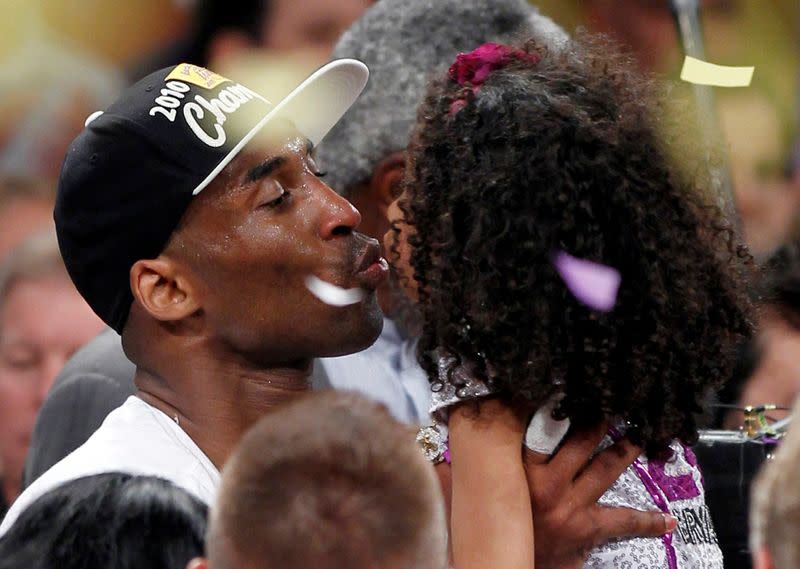 FILE PHOTO: Los Angeles Lakers' Bryant kisses his daughter after the Lakers defeated the Boston Celtics in Los Angeles