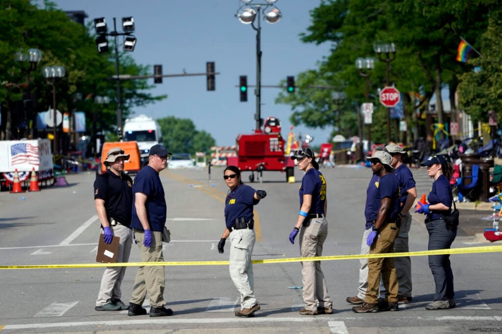 Members of the FBI’s evidence response team organize on Tuesday, July 5, 2022, one day after a mass shooting in downtown Highland Park, Ill. A shooter fired on an Independence Day parade from a rooftop, spraying the crowd with gunshots initially mistaken for fireworks before hundreds of panicked revelers of all ages fled in terror. (AP Photo/Charles Rex Arbogast)