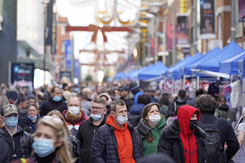 People crowd a shopping street ahead of Christmas in Dublin, Ireland, Thursday, Dec. 23, 2021. (Niall Carson/PA via AP)