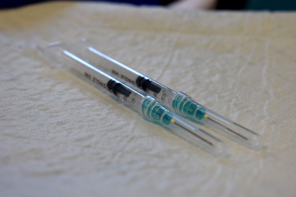 Registered nurse Dawn Fessel holds out a tray carrying a pair of Pfizer COVID-19 vaccine doses Monday, April 5, 2021, at the Fort Pierce Recreation Center.