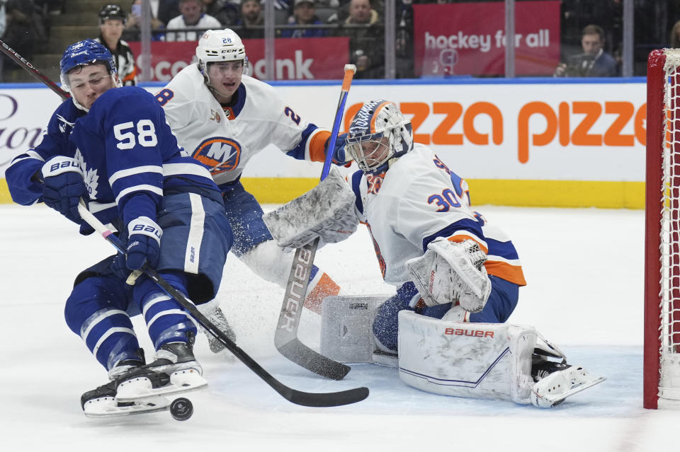 Toronto Maple Leafs left wing Michael Bunting (58) is awarded a penalty shot as he taken down by New York Islanders defenseman Alexander Romanov (28) in front of Islanders goaltender Ilya Sorokin (30) during second-period NHL hockey game action in Toronto, Ontario, Monday, Jan. 23, 2023. (Nathan Denette/The Canadian Press via AP)