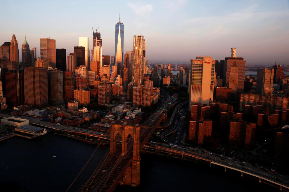 The rising sun lights the Brooklyn Bridge and One World Trade in the Manhattan borough of New York, U.S.,November 2, 2016. REUTERS/Lucas Jackson