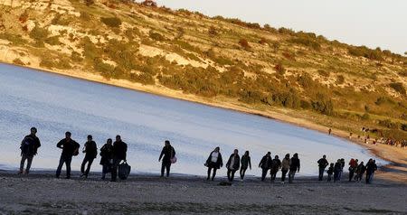 Refugees walk along a beach before trying to travel to the Greek island of Chios from the western Turkish coastal town of Cesme, in Izmir province, Turkey, March 5, 2016. REUTERS/Umit Bektas