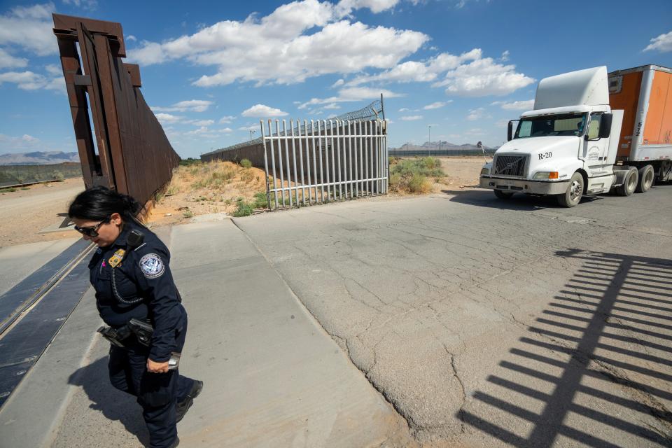 A U.S. Customs and Border Protection Chief Cecilia Esparza walks past the border wall while Mexican truck drivers await entry from San Jeronimo, Mexico (right) to Santa Teresa, New Mexico on . About 700 trucks from Mexico use this port of entry daily. Foxconn, the Taiwan-based manufacturer of personal computers and computer components built the plant across the border San Jeronimo, Mexico.