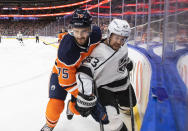 Los Angeles Kings' Viktor Arvidsson (33) is checked by Edmonton Oilers' Evan Bouchard (75) during the first period of an NHL hockey game in Edmonton, Alberta, Sunday, Dec. 5, 2021. (Jason Franson/The Canadian Press via AP)