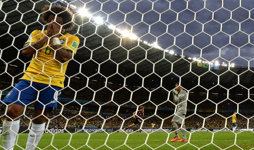 Brazil's defender Marcelo reacts after Germany scored during the semi-final football match between Brazil and Germany at The Mineirao Stadium in Belo Horizonte during the 2014 FIFA World Cup on July 8, 2014