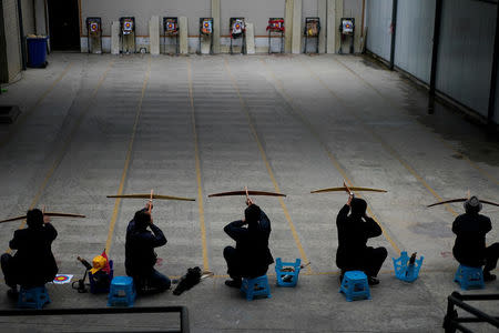 Ethnic Lisu men aim their crossbows during a crossbow shooting training session at Lushui Crossbow Stadium of Nujiang Lisu Autonomous Prefecture in Yunnan province, China, March 27, 2018. REUTERS/Aly Song