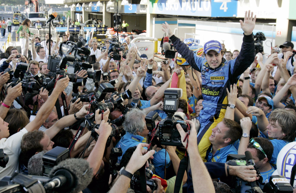 Renault's Formula One driver Fernando Alonso of Spain celebrates with the Renault team after finishing second in the Brazilian Grand Prix, the last F1 race of the season, at the Interlagos track in Sao Paulo, October 22, 2006. Alonso of Spain won his second successive Formula One world championship at the Brazilian Grand Prix on Sunday. The 25-year-old Spaniard, needing only one point to secure the title, finished second in the season-ending race at Interlagos. Ferrari's Michael Schumacher, who had to win to have any hope of a record eighth title in his last race before retirement, was fourth.      REUTERS/Bruno Domingos (BRAZIL)