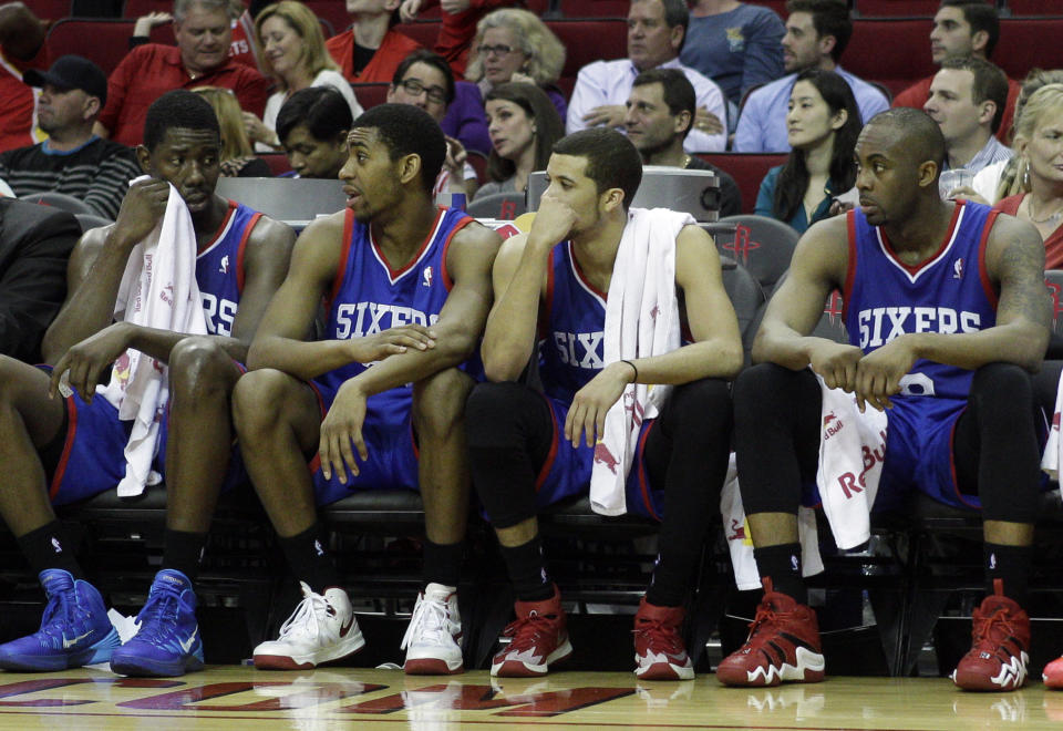 From left to right, Philadelphia 76ers' Henry Sims, Hollis Thompson, Michael Carter-Williams and James Anderson watch the final minutes during the second half of an NBA basketball game against the Houston Rockets, Thursday, March 27, 2014, in Houston. Houston won 120-98. (AP Photo/Bob Levey)