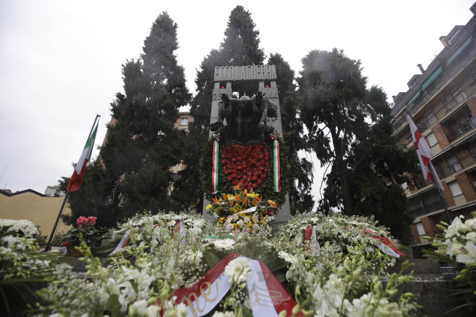 Flowers lie in front of a bronze ossuary monument entitled 'Ecco La Guerra', (Here is War) dedicated to the 'Little Martyrs of Gorla', in memory of a World War II bombing raid on Oct. 20 1944 is pictured in Milan, Italy, Sunday, Oct. 20, 2019. Milan's mayor Giuseppe Sala, following a Mass Sunday for the 75th anniversary of the raid, asked U.S. authorities to apologize for a World War II bombing raid that killed 184 elementary school children. (AP Photo/Luca Bruno)