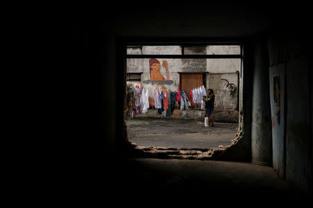 A woman hangs laundry at the abandoned Prestes Maia textile factory occupied by a homeless movement in downtown Sao Paulo, Brazil, May 8, 2018. REUTERS/Nacho Doce