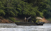 A Federal Police motor boat patrol the river after more than 60 dredging barges were set on fire by officers of the Brazilian Institute of the Environment and Renewable Natural Resources, IBAMA, during an operation to try to contain illegal gold mining on the Madeira river, a tributary of the Amazon river in Borba, Amazonas state, Brazil, Sunday, Nov. 28, 2021. Hundreds of barges belonging to illegal miners had converged on the river during a gold rush in the Brazilian Amazon prompting IBAMA authorities to start burning them. (AP Photo/Edmar Barros)