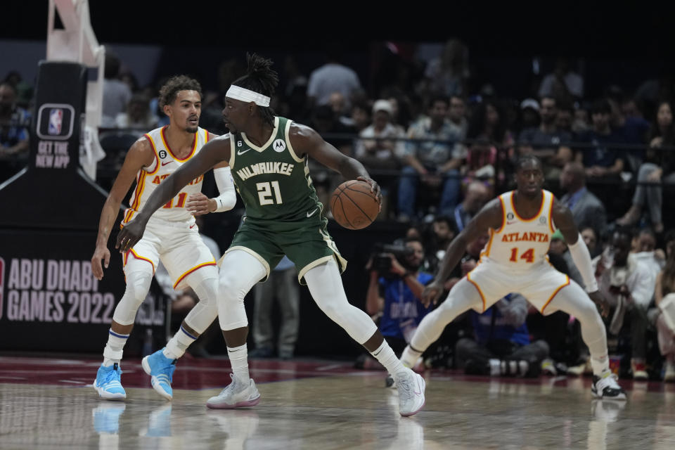 Trae Young of Atlanta Hawks guards Jrue Holiday of Milwaukee Bucks during a preseason NBA basketball game in Abu Dhabi, United Arab Emirates, Saturday, Oct. 8, 2022. (AP Photo/Kamran Jebreili)