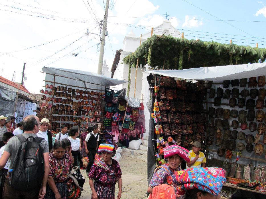 This February 2013 photo shows Mayan women selling colorful Guatemalan fabrics in front of market stalls in Chichicastenango, Guatemala. Chichicastenango is also famed for its expansive local crafts market. (AP Photo/Amir Bibawy)